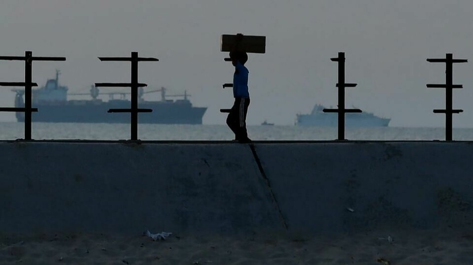 En palestinsk gutt bærer på en nødhjelpspakke som ble brakt inn til den midlertidige amerikanske brygga i Gaza i forrige uke. Foto: Saher Alghorra / AP / NTB