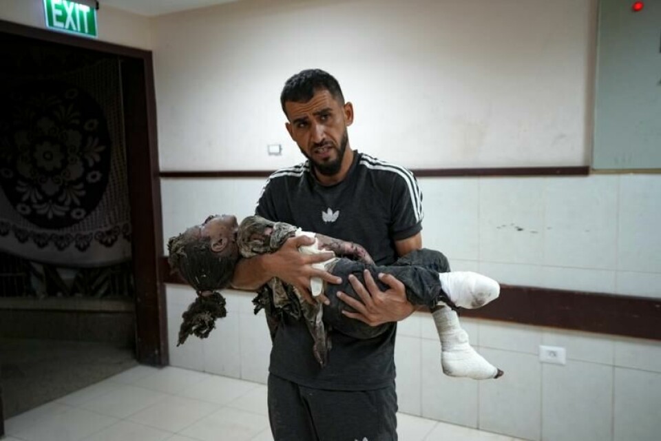 En palestinsk mann bærer et lite barn som ble hardt skadet i et israelsk bombeangrep mot Gazastripen tidligere i høst. Flere helseorganisasjoner krever nå at Israel tillater evakuering av sårede til sykehus i Øst-Jerusalem.