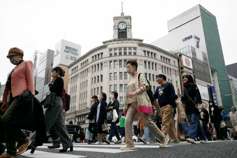 Inflasjonen i Japan dempet seg fra januar til februar, men er fortsatt høyere enn sentralbankens inflasjonsmål. Bildet viser folk som går over gaten i shoppingområdet Ginza i Tokyo.
