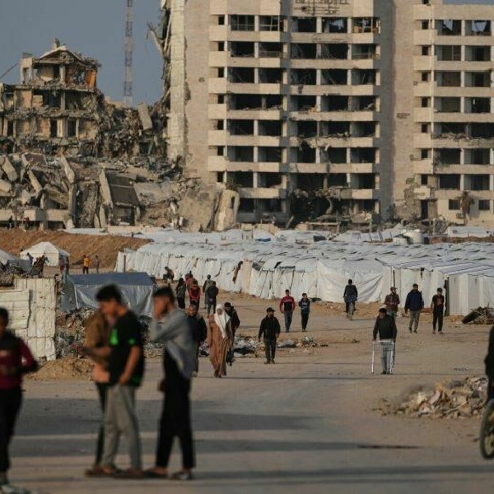 Palestinere går ved siden av en teltleir for fordrevne vest på Gazastripen.