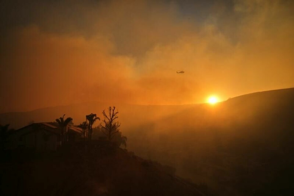Et brannhelikopter i solnedgangen over Los Angeles torsdag.