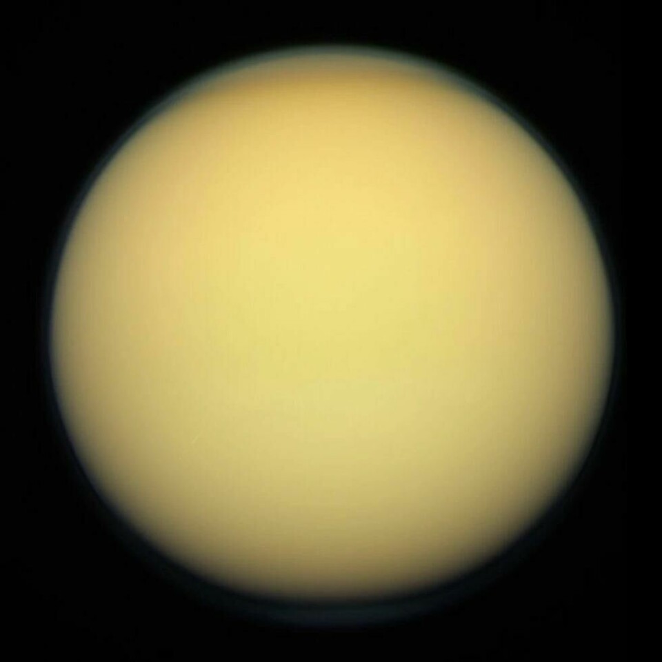 Slik ser Titan ut fra rommet. Den er dekket av en tykk og tåkete atmosfære som består hovedsakelig av nitrogen, men en del metan. Slik ser Titan ut fra rommet. Den er dekket av en tykk og tåkete atmosfære som består hovedsakelig av nitrogen, men en del metan. Foto: Nasa/JPL