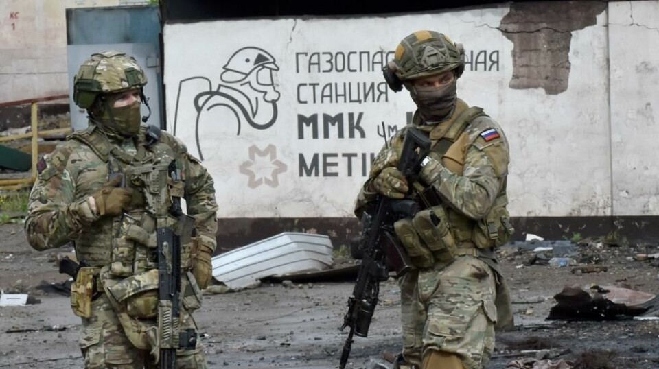 Russiske soldater står vakt ved den ødelagte delen av Iljitsj jern- og stålverk i havnebyen Mariupol i Ukraina i mai 2022. Illustrasjonsfoto.