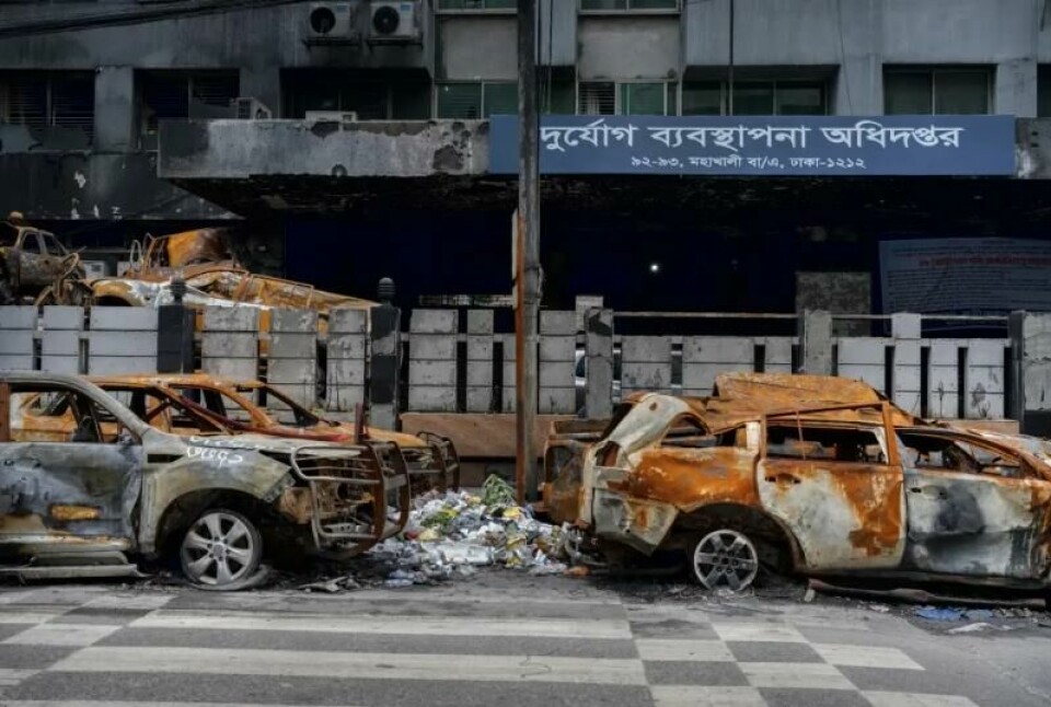 Vrakene av biler som ble tent på under demonstrasjonene i sommer står igjen foran departementet for krisehåndtering og nødhjelp i Dhaka. Vrakene av biler som ble tent på under demonstrasjonene i sommer står igjen foran departementet for krisehåndtering og nødhjelp i Dhaka. Foto: Panorama nyheter