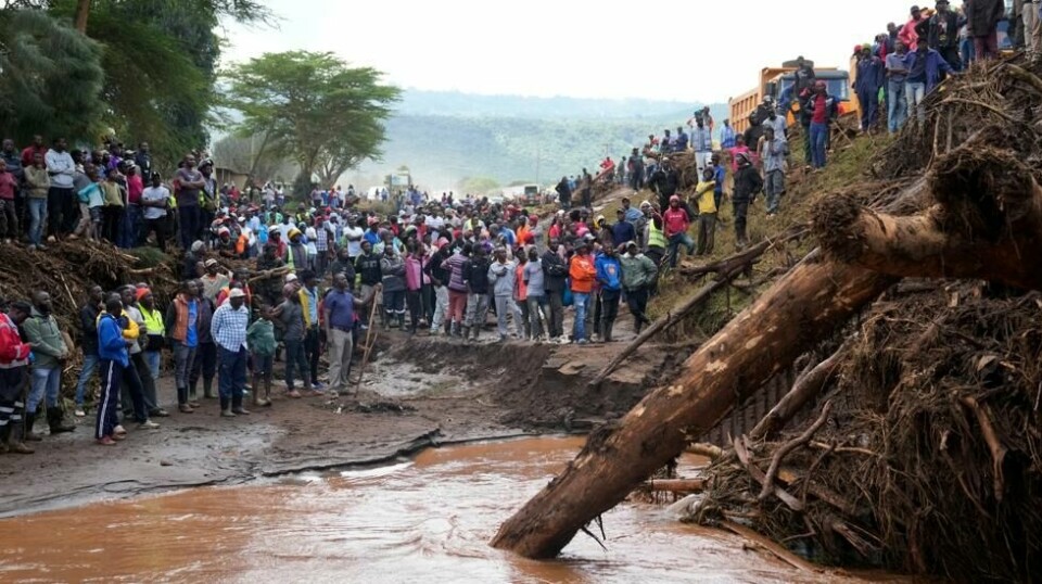 Folk samler seg ved en bro der en død kvinne ble funnet etter at flomvann tok flere hus i landsbyen Kamuchiri i Nakuru-fylket i Kenya. 228 mennesker har mistet livet som følge av flom og skred i Kenya, opplyser landets innenriksdepartement. Foto: Brian Inganga / AP / NTB