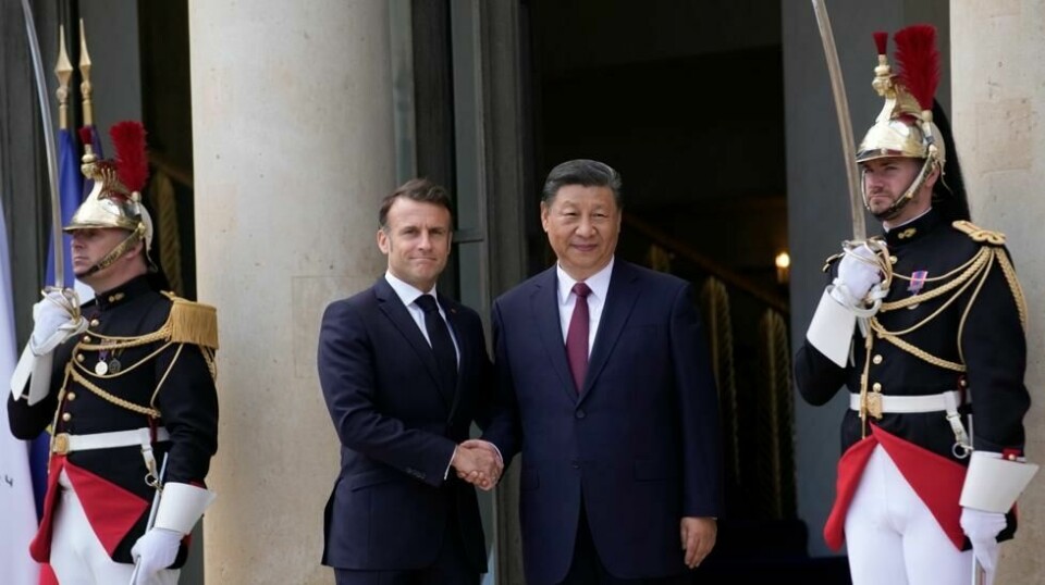 Frankrikes president Emmanuel Macron og Kinas president Xi Jinping tar hverandre i hånden ved innledningen av møtet i Paris mandag. Foto: Christophe Ena / AP / NTB