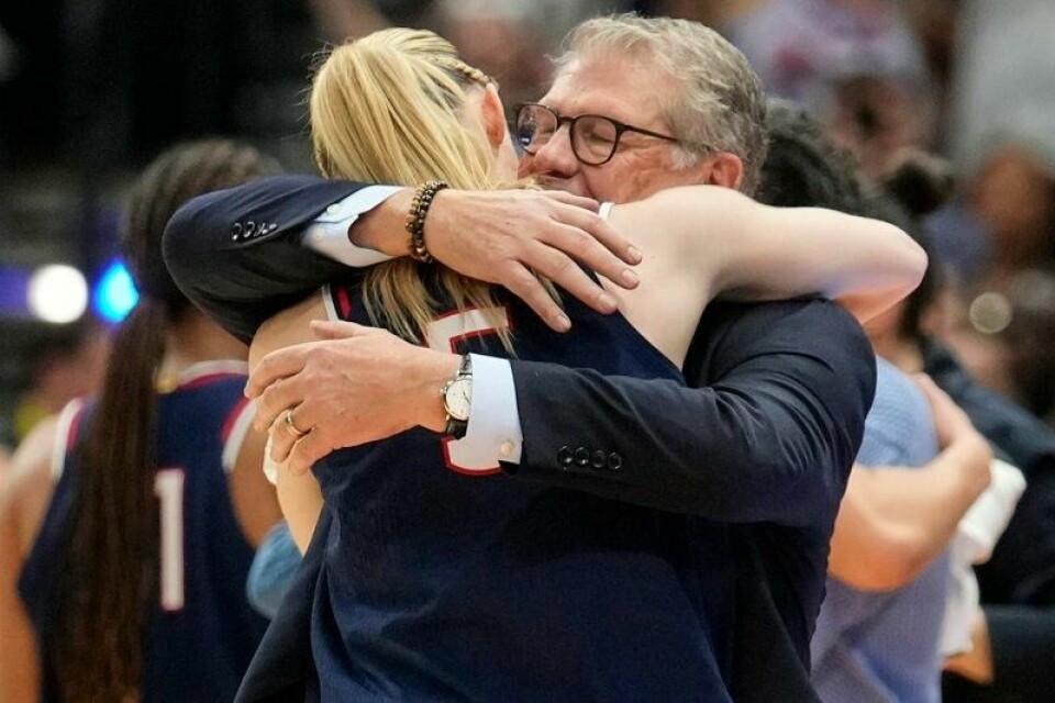 UConn-trener Geno Auriemma omfavner stjernespilleren Paige Bueckers etter at South Carolina ble knust i NCAA-finalen. Det var 12. tittel for Auriemma, den første for Bueckers.