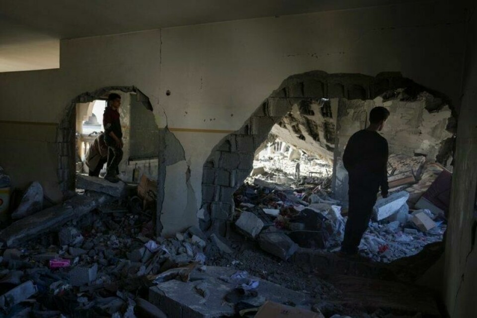 To palestinere ser på ruinene av en bygning som ble ødelagt i det israelske angrepet på Gazastripen natt til tirsdag.