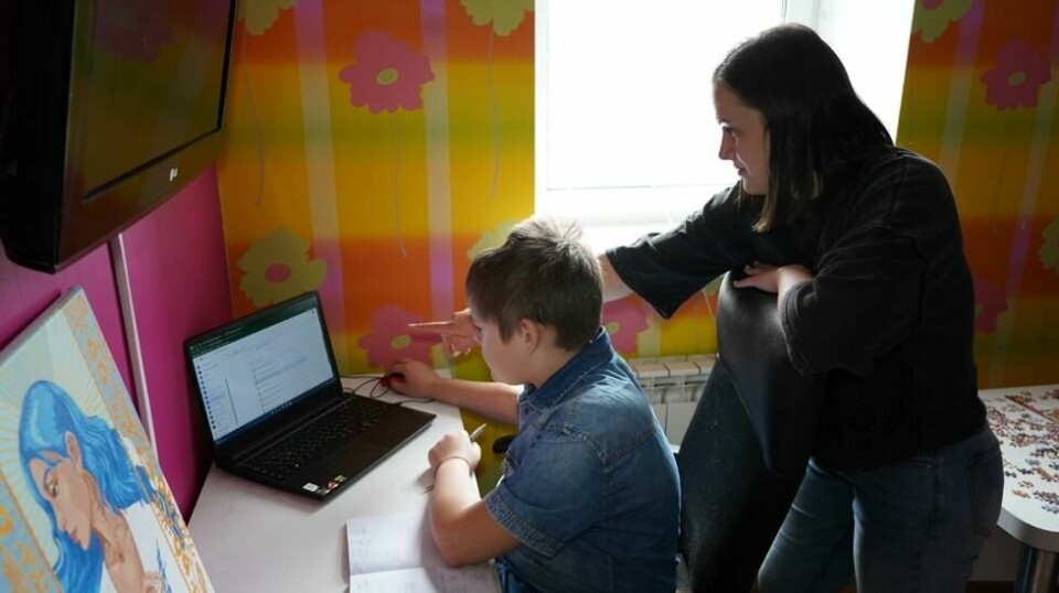 Olesia hjelper sønnen Anton som får fjernundervisning i Mykolaiv sør i Ukraina, nær fronten mot den russiskokkuperte delen av landet. 44 prosent av alle ukrainske skolebarn kan ikke lenger fysisk gå på skolen. Foto: Artem Rybakov / Redd Barna / NTB