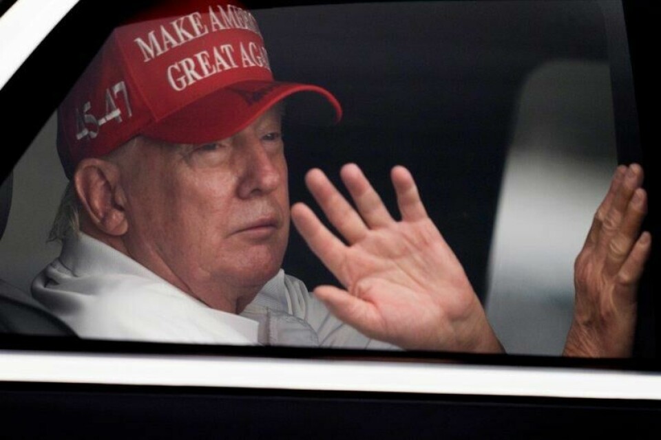 President Donald Trump vinker til tilhengere i det han ankommer golfklubben sin i Florida lørdag.
