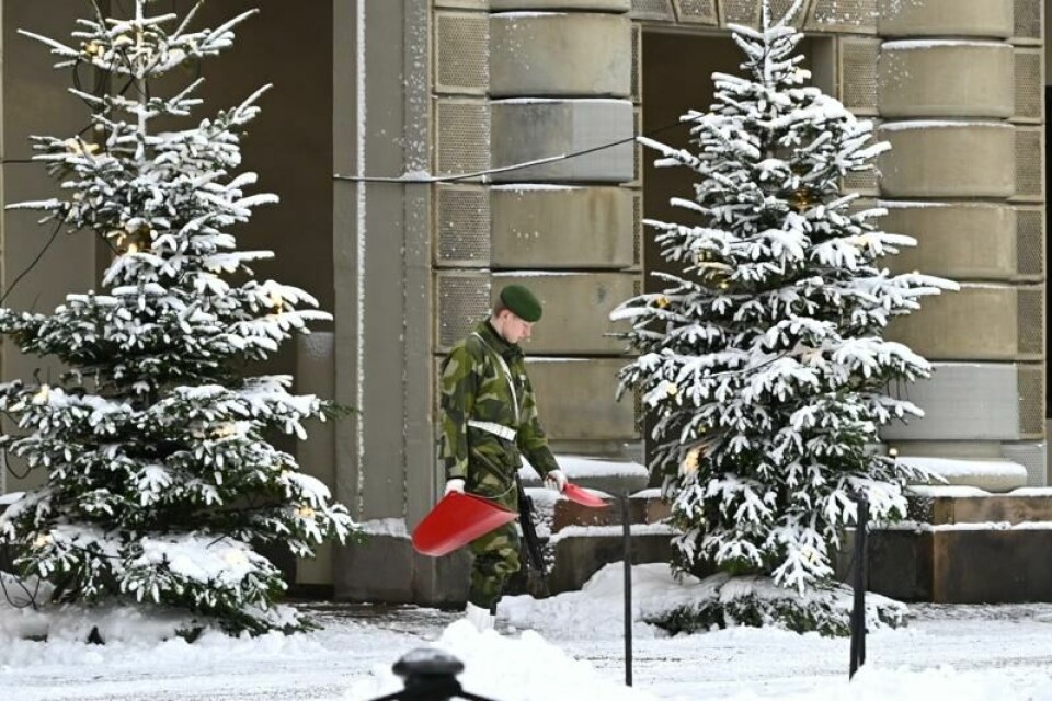 En soldat strør sand foran slottet i Stockholm etter at en gardist skled på isen og skadet seg lørdag. En soldat strør sand foran slottet i Stockholm etter at en gardist skled på isen og skadet seg lørdag. Foto: Anders Wiklund/TT / NTB