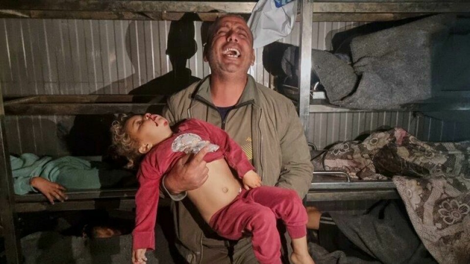 En mann holder et dødt barn på likhuset i Khan Younis, sør på Gazastripen, etter israelske luftangrep natt til tirsdag.