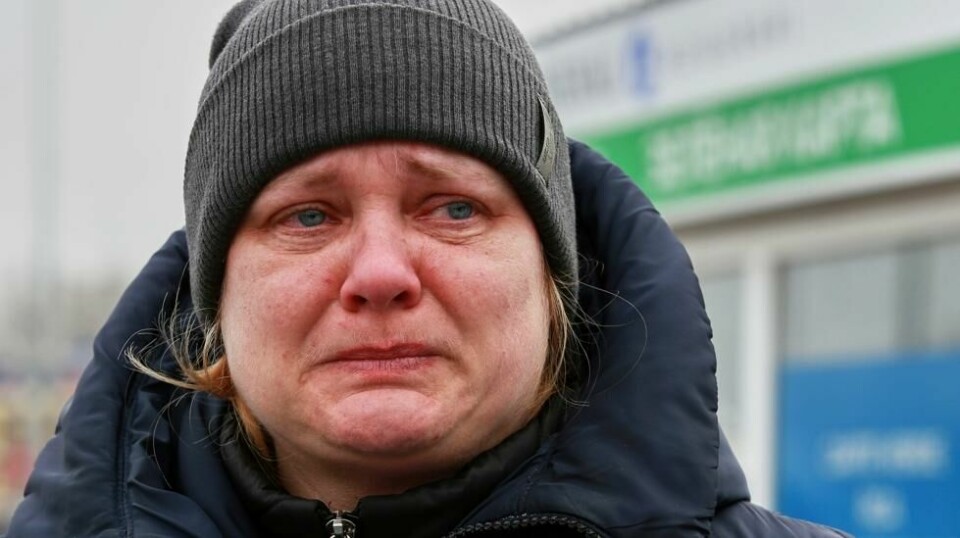 En ukrainsk kvinne gråter i det hun flykter over grensen til Moldova.