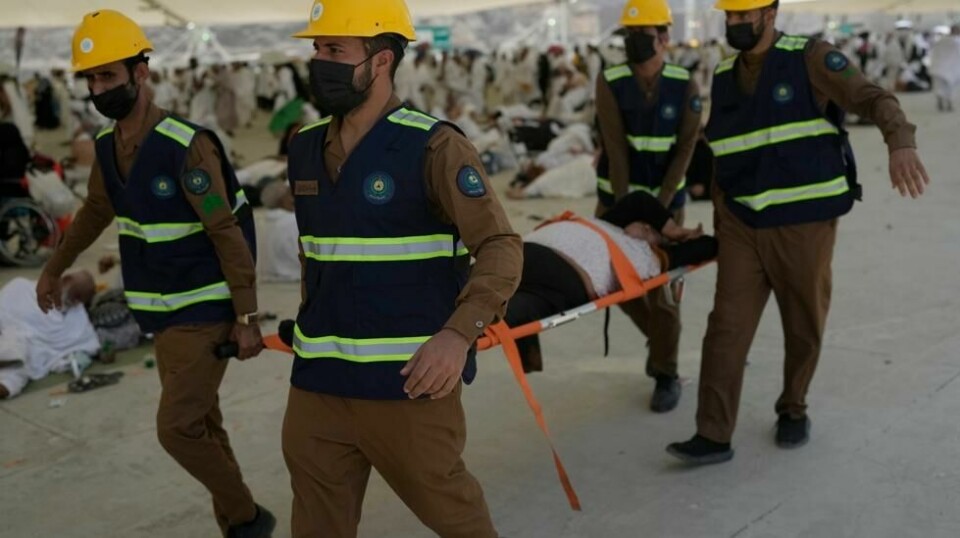 En pilegrim bæres bort av helsepersonell etter å ha fått heteslag nær Mekka søndag. Foto: Rafiq Maqbool /AP / NTB