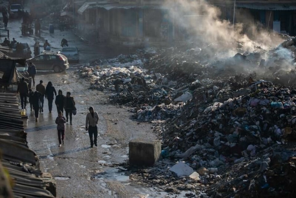 Palestinere går langs store mengder avfall i Gaza by onsdag.