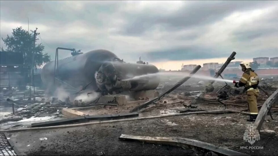 Bilder fra det russiske departementet for krisesituasjoner viser en brannmann som driver etterslukking på bensinstasjonen i Groznyj. To voksne og to barn mistet livet da en drivstofftank eksploderte og utløste en brann på bensinstasjonen lørdag. Foto: AP / NTB