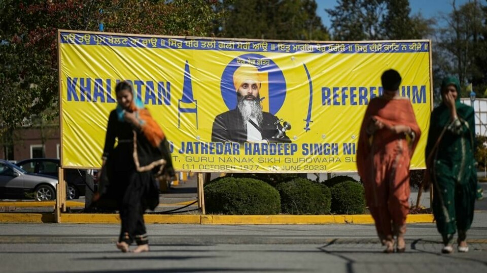 Et banner med bilde av Hardeep Singh Nijjar i nærheten av stedet der han ble drept i en forstad til Vancouver i fjor.