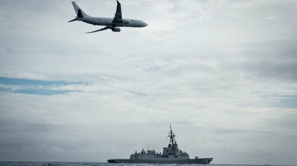 Et bildet tatt 24. februar viser et amerikansk fly av typen P-8A fly over australske HMAS Hobart.