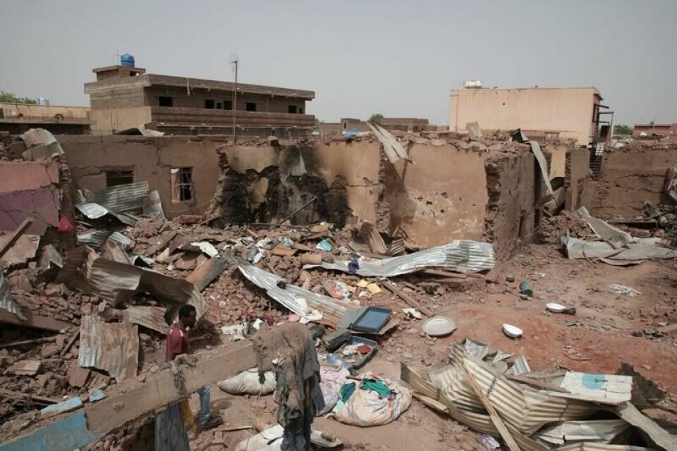 En mann passerer forbi et hus som er ødelagt i kamper i Khartoum i april 2023. For første gang siden da er en hjelpesending nå kommet fram til den sudanske hovedstaden, ifølge UD.