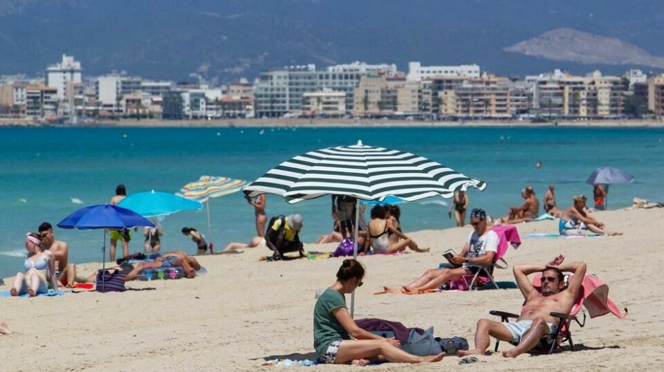 Turistene soler seg på stranden i Palma de Mallorca. Nå stiger også coronasmitten på Mallorca og antallet sykehusinnleggelser har skutt i været. Arkivfoto