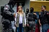 Lilian Tintori (2 f.v.), kona til den venezuelanske opposisjonslederen Leopoldo Lopez, som sitter i husarrest, ved inngangen til deres hjem. Medlemmer av bolivariansk etterretning vokter boligen i Caracas. Scanpix/EPA.