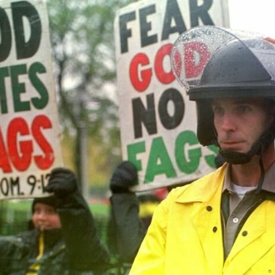 En politimann holder vakt utenfor minnesermonien for Matthew Shepard, der medlemmer av anti-homofile Westboro Baptist Church kom med demonstrasjonsskilt og skjellsord. Foto: Doug Collier/AFP En politimann holder vakt utenfor minnesermonien for Matthew Shepard, der medlemmer av anti-homofile Westboro Baptist Church kom med demonstrasjonsskilt og skjellsord. Foto: Doug Collier/AFP
