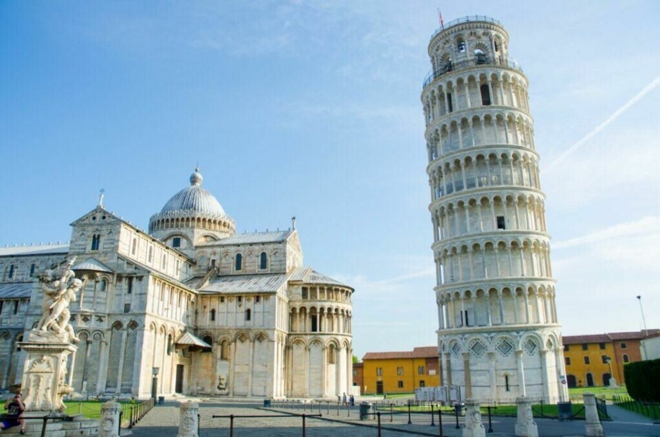 Toscana i Italia byr blant annet på byen Pisa som er spesielt kjent for sitt skjeve tårn. (Foto: Colourbox) Bilde av det skjeve tårnet i Pisa, Italia, på en solrik dag med blå himmel. Til venstre i bildet er katedralen i Pisa med sin store kuppel og intrikate fasade. Foran katedralen står en statue, og til høyre sees det berømte skjeve tårnet som lener seg tydelig til siden. Rundt bygningene er det åpne områder med gress og enkelte besøkende som går rundt. Vi har laget en omfattende guide til Toscana i Italia hvor vi blant annet forteller om fem populære byer som Firenze, Pisa, Siena, Montepulciano og Volterra. Vi gir deg også forslag til tre kjøreruter du kan ta for å oppleve vingårder og resten av Toscana. La deg inspirere av den italienske regionen som fikk sitt eget TV-program; «Den store matfesten - Toscana»