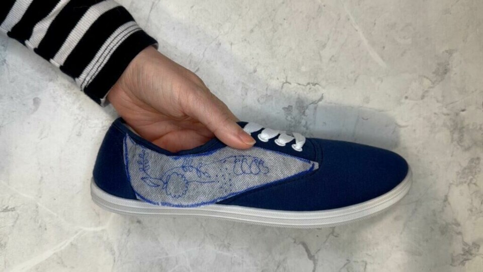 Legg mellomleggspapiret der du ønsker å brodere mønsteret. (Foto: Kreative Ideer/ Miriam Schjetlein) Blå tøysko med et stykke broderingsmellomlegg oppå.