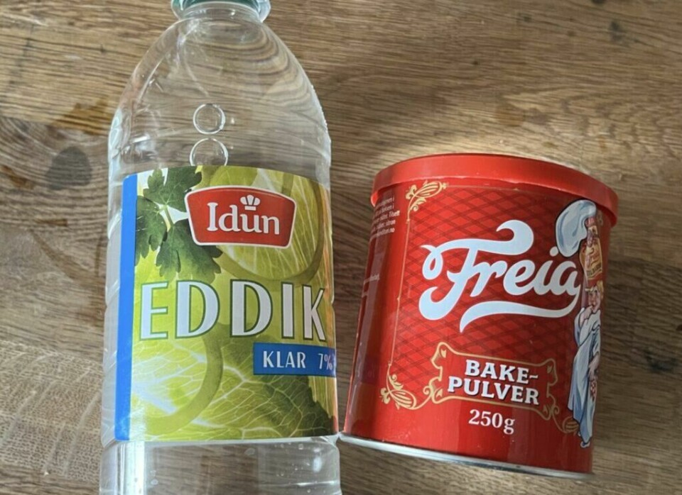 (Foto: ABC Guider) Bilde av en flaske eddik og en boks bakepulver på en kjøkkenbenk av tre, de skal brukes til å åpne et tett sluk.