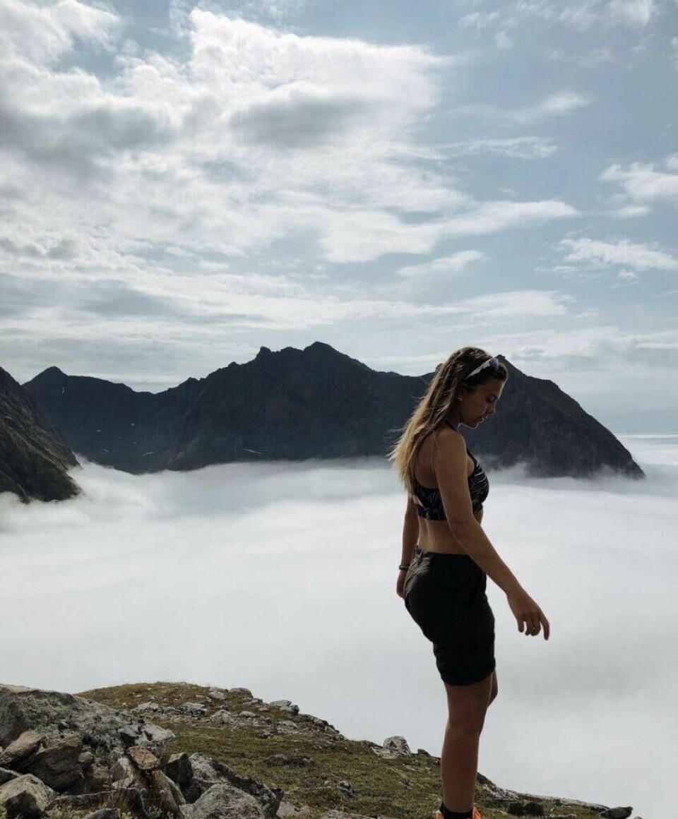 Sommerfelt Ovenstad har vært en ivrig turgåer siden barndommen og foreldrene dro henne ukentlig med ut på eventyr i naturen. Bilde av Runa Sommerfelt Ovenstad som står på toppen av et fjell med utsikt over skyer og andre fjell. Runa har gitt oss sine beste tips til hva du må ha på pakkelista om du planlegger fjellturer i sommer. Hun avslører også sine favoritt-fjellturer i Norge!