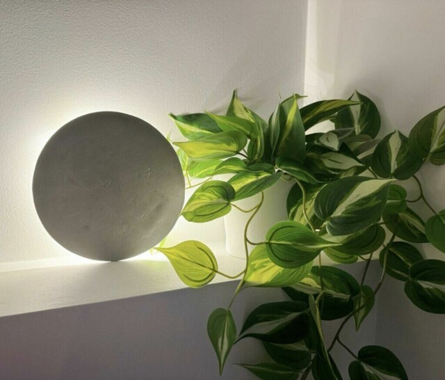 Hjemmelaget lampe av selvtørkende leire, skaper en myk og elegant belysning sammen med en grønn plante. (Foto: Kreative ideer/ Aurora Lange)