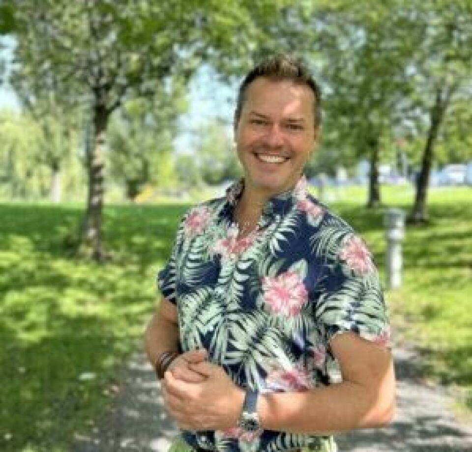 Hageeksperten vår Espen Skarphagen. Bildet viser Espen Skarphagen, også kjent som “Skarp i hagen,” som smiler mens han står utendørs i en park. Han har på seg en fargerik, blomstrete skjorte med grønne blader og rosa blomster. I bakgrunnen kan man se grønne trær og gress, samt en gangsti som går gjennom parken. Det ser ut til å være en solfylt dag, og omgivelsene gir et avslappet og naturlig inntrykk. Espen ser glad og fornøyd ut, og bildet fanger en hyggelig, rolig stemning i naturskjønne omgivelser. Espen Skarphagen svarer på dine spørsmål om hage, blomster og planter.