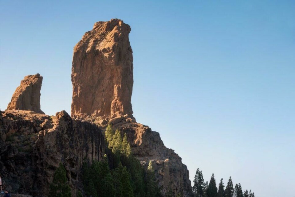 Roque Nublo ligger i den sentrale kommunen Tejeda på Gran Canaria og regnes som ett av de største naturlige klippefremspringene i verden. (Foto: Colourbox) Roque Nublo - På bildet ser du en stor stein som står oppreist på toppen av fjellet med blå himmel i bakgrunnen. Her får du en guide til Kanariøya fra noen som har bodd der i mange år og som skriver for Canariajournalen.