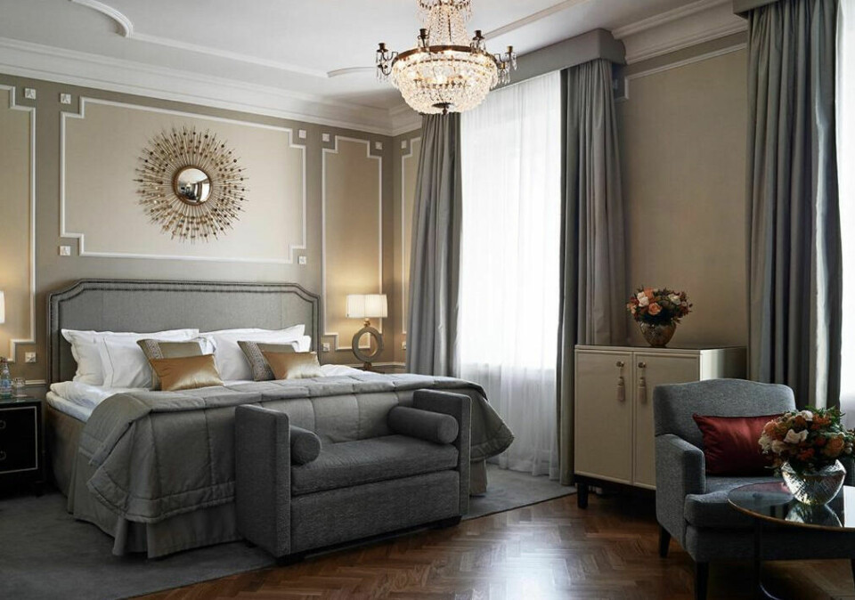 Grand Hotel i Stockholm er et hotell midt i Stockholm sentrum. (Foto: Booking.no) Dobbeltseng på hotellrom på Grand Hotel i Stockholm med tunge gardiner og beige fargepalett.