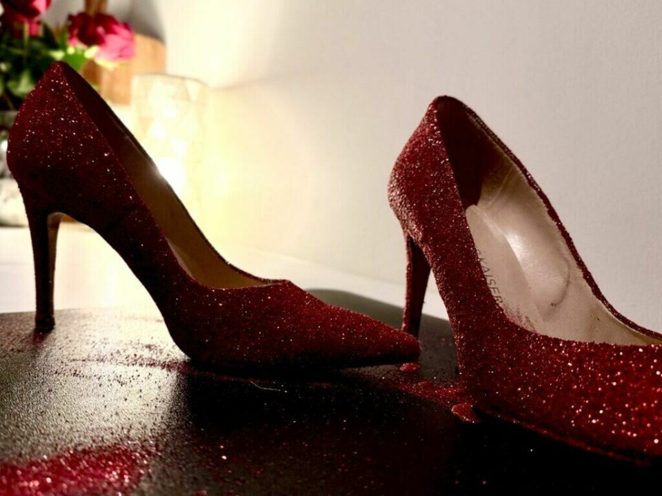 Elegante røde høyhælte sko med glitter og dekorativ sløyfe – perfekt til festlige anledninger. Få en luksuriøs og iøynefallende stil med dette tidløse designet fra Peter Kaiser. (Foto: Kreative Ideer/Aurora) Et par elegante røde høyhælte sko dekket med glitrende rød glitter. Den ene skoen har en dekorativ sløyfe som tilfører et ekstra festlig preg. Merket 'Peter Kaiser' er synlig på innsiden av skoen. Bildet fremhever detaljene i glitteret og den sofistikerte designen, ideelt for spesielle anledninger som bryllup, fester eller julefeiringer.
