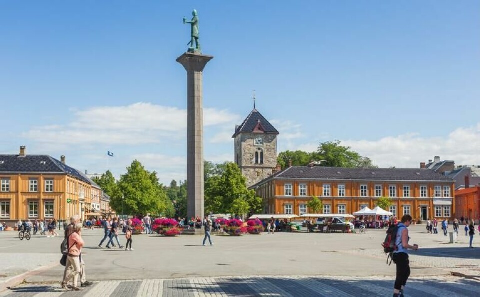 Trondheim Torg: Den intime bykjernen, med mange små og store butikker, gjør Trondheim til en populær shoppingby. (Foto: Canva) Statue av Olav Tryggvason midt på Trondheim Torg i solskinn.