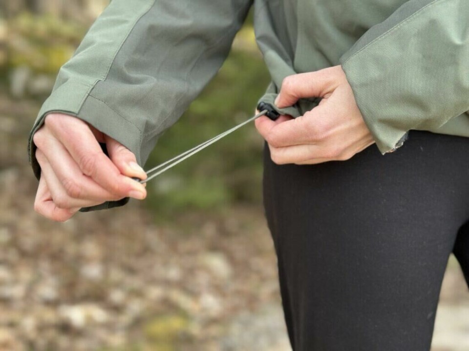 «Jakken som elsker dårlig vær», «utmerket vær-beskyttelse», «god pusteevne» og «ten tvil, Arc'teryx lager våre favoritt skalljakker» er blant kommentarene fra ekspertene i det de kårer årets beste skalljakker til dame og herre i 2025. Vi avslører hvilke det gjelder. (Foto: Mari-Ann Greiner Green) Nærbilde av en person som strammer strikkjusteringen nederst på en grønn skalljakke. Personen holder snoren med begge hender, og jakken har en enkel, praktisk design med slitesterkt stoff. Bakgrunnen er uskarp, men viser tydelig at bildet er tatt utendørs i et skogsområde med blader og mose på bakken. Bildet illustrerer funksjonaliteten og justeringsmulighetene på en tur- eller friluftsjakke, og passer godt i sammenheng med produktomtale eller test av skalljakker. Disse skalljakkene er best i test i 2024! Best i test i 2025: Arc’teryx Alpha SV Jacket – Skalljakken som tåler alt, Norrøna Trollveggen Gore-Tex Pro Light: Best i test i 2024, Arc’teryx-skalljakken «Beta AR»: Best av dem alle i 2025, Rab Namche: Beste «billige» skalljakke i 2025, Mammut Nordwand Advanced.