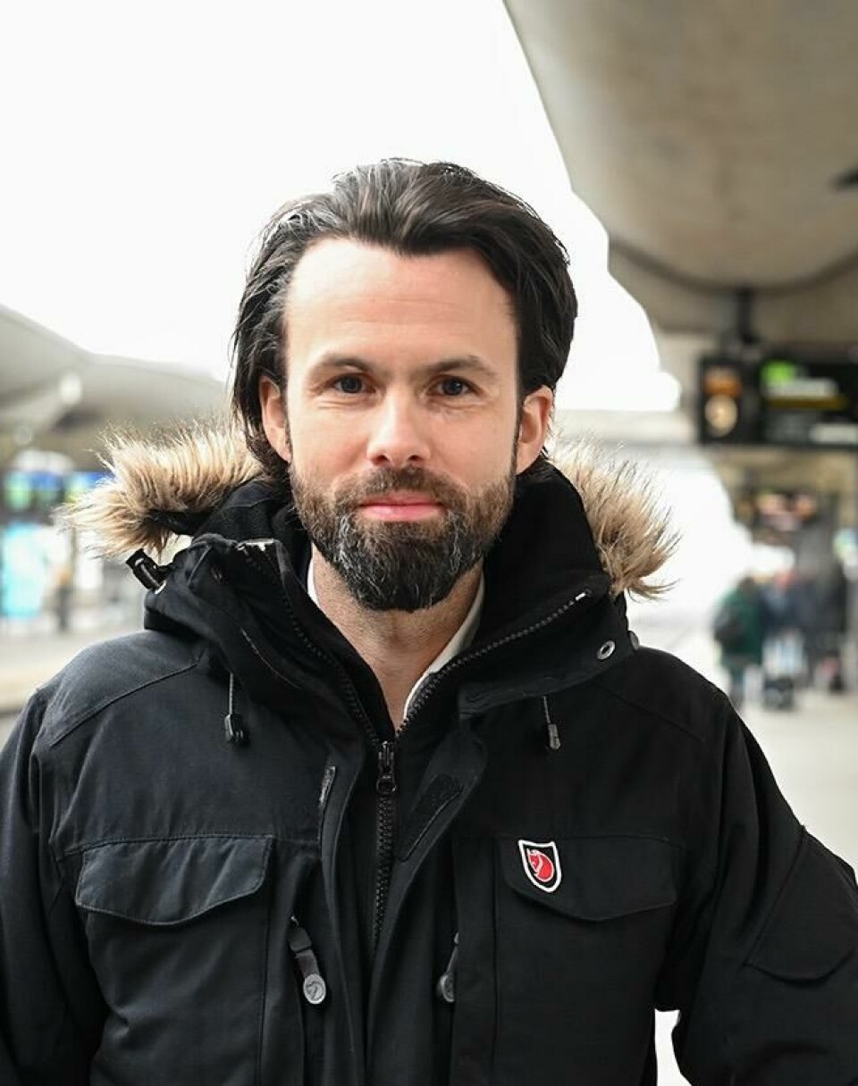 Seniorrådgiver i Forbrukerrådet, Thomas Iversen, forteller hvilke krav du har når flyet er forsinket og du får utlevert en matkupong. Bilde av en mann som står på en togstasjon, han har mørkt hår og sjeggvekst og står i en tykk sort parkas. Vi har snakket med Forbrukerrådet som forteller hvilke krav man har til mat og drikke dersom flyet er forsinket og man må få matkupong.