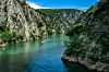 Et bilde av Matka Canyon i Nord-Makedonia, der en liten båt glir stille gjennom det turkisfargede vannet som er omringet av bratte klipper og frodig, grønn vegetasjon. Høye fjellvegger dominerer landskapet. Vannet reflekterer de lysegrønne tonene fra trærne og det mørkeblå fra himmelen. Nord-Makedonia har blitt rangert som landet i Europa som er billigst for nordmenn å feriere i. Vi har samlet fem ting du bør se og gjøre i landet, samt hjelper deg med å finne billige reiser ved hjelp av restplasser.