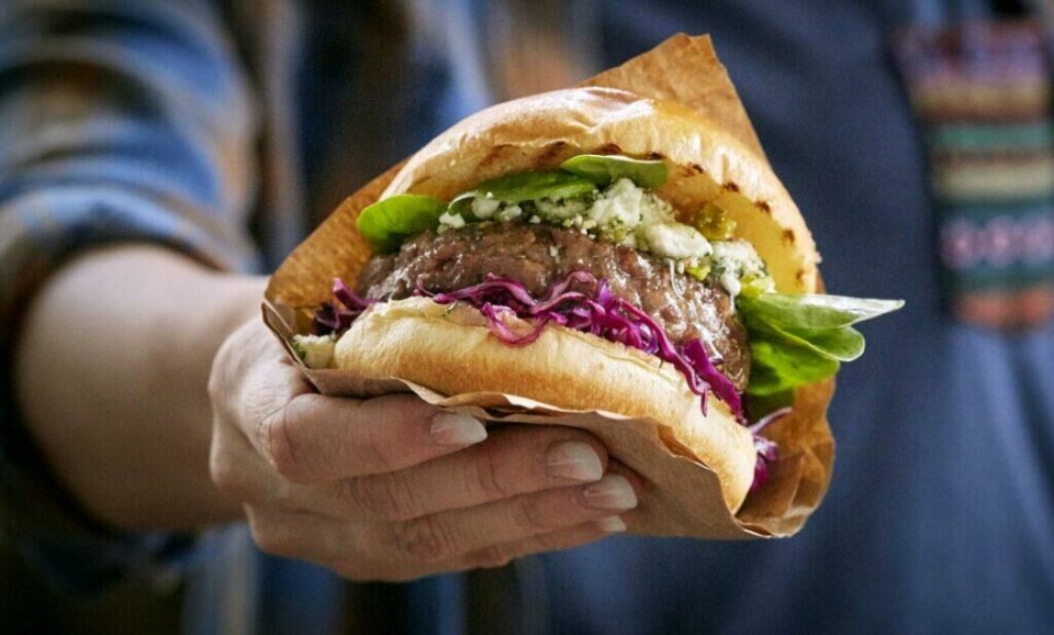 En lammeburger på grillen til påskemiddagen er en slager for voksne o barn. (Foto: Matprat.no) Bilde av hand som holder en lammeburger