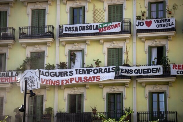 En boligblokk som er truet av utkastelse, er fotografert i sentrum av Barcelona, Spania, onsdag 10. juli 2024. På banneret i midten står det på katalansk: «midlertidige utleieboliger: naboer kastet ut». (AP Photo/Emilio Morenatti, File) (Foto: AP Photo/Emilio Morenatti, File)