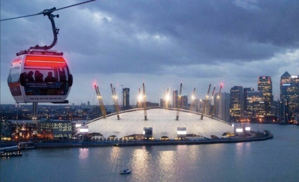 Kabelbil på Emirates Air Line pod på vei over Themsen tar deg fra Royal Victoria Dock til Greenwich Park og tilbake. (Foto: Booking.com) Bilde av en kabelbil av Emirates Air Line pod en kveld i London.