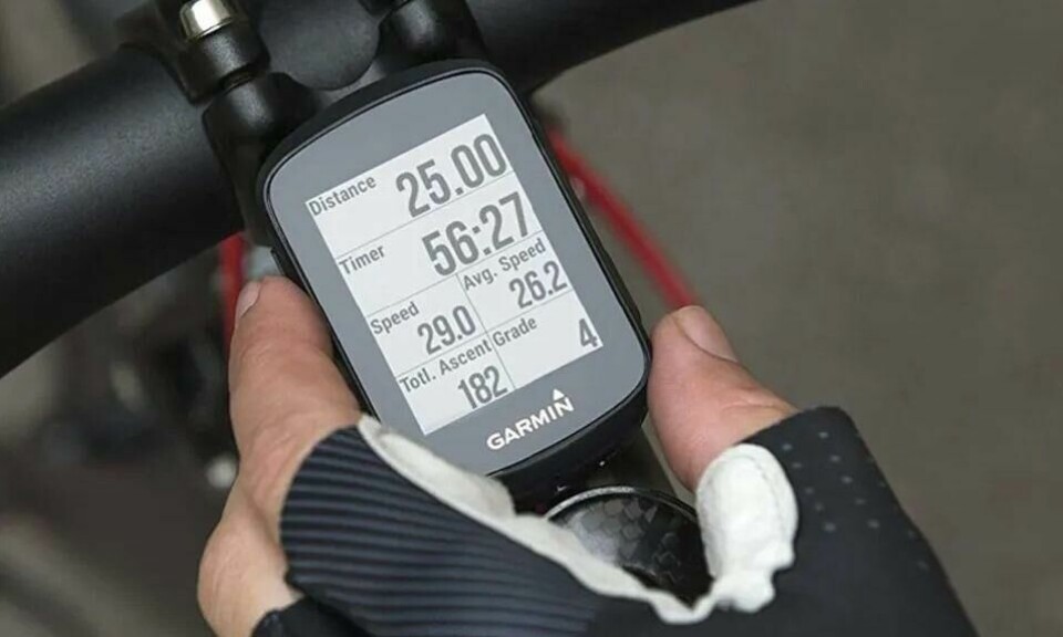 En GPS sykkelcomputer gjør sykkelturen enda morsommere! Sett deg mål, oppnå og kjenn på mestringsfølelsen. (Foto: Anton Sport) Bilde av hand med hansker som holder en GPS-klokke festet på sykkel.