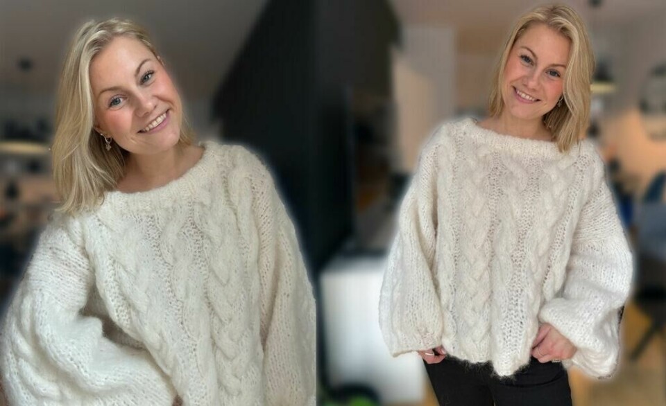 Strikkegenseren Vinterdrøm – en lun og pusete genser med vakre fletter. (Foto: Knitting by Emilie) Bildet viser Emilie fra Knitting by Emilie iført den hjemmestrikkede genseren Vinterdrøm. Genseren er laget i mykt, fluffy garn og har et mønster med store flettestrikkede detaljer. Den har en løs passform med vide ermer og en bred båthals, noe som gir et avslappet og stilrent uttrykk. Bakgrunnen er en moderne og dempet innendørs setting, der Emilie smiler varmt mot kameraet.
