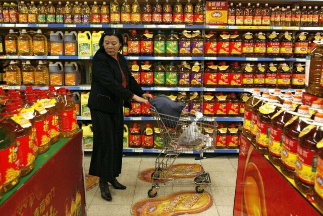 En kunde sjekker priser på matolje i et supermarked i Shenyang, Kina, 3. april 2008. Inflasjonen i Kina fører til økte matvarepriser, noe som tvinger mange til å stramme inn økonomien. Foto: AFP. (Foto: AFP)