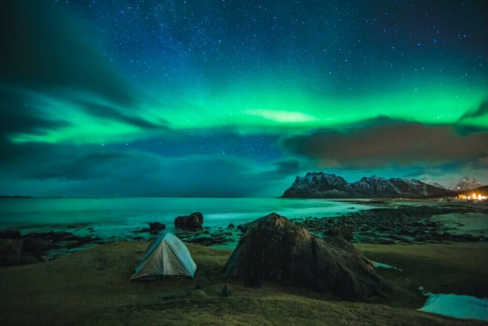 Nord-Norge er blant verdens beste sted å se nordlyset. Her er det nordlys nesten hver dag. De beste månedene for å se nordlys er fra september til midten av mars, Bildet er tatt på stranden Uttakleiv på Vestvågøy i Lofoten. (Foto: Samuel Taipale - VisitNorway.com) nordlys eller aurora borealis over uttakleiv strand i lofoten. telt i skråningen.
