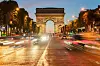 Paris - triumfbuen/ Arc de Triomphe en kveld med gatelys og trafikk. Vi gir deg en omfattende guide til kjærlighetens by som kan by på alt fra Triumfbuen, Louvre, Notre-Dame, Disneyland Paris og mye mer.