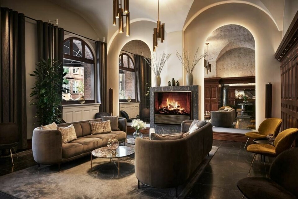 Den flotte lobbyen på Hotel Ascot i København. (Foto: Booking.com) Bilde av lobbyen på Ascot hotel i København. Flotte møbler i natur og duse farger og stor peis.