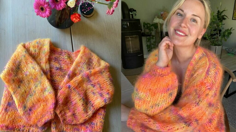 Den myke og fargerike Mari Cardi fra VildKnitwear, strikket i mohair på tykke pinner for et luftig og varmt plagg. (Foto: VildKnitwear) Bildet viser en fargerik, håndstrikket cardigan laget i myk mohair. Til venstre ligger cardiganen brettet på et trebord, omgitt av en vase med friske blomster i sterke farger. Til høyre har en smilende kvinne den på seg, sittende ved et bord i en koselig innredet stue med grønne planter og en vedovn i bakgrunnen. Den fluffy strikkegenseren har varme toner av oransje, rosa og gult, strikket med tykke pinner for et luftig uttrykk.