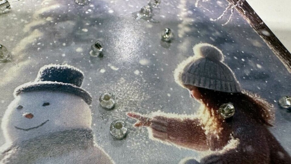 Julekort med 3D-effekt og glassperler – perfekt for nostalgisk julestemning. (Foto: Kreative Ideer/ Aurora Lange) Et nostalgisk julekort med 3D-glassperler. Kortet viser to barn i vinterlandskap som bygger en snømann, omgitt av snøfnugg og med en klassisk leketøysbil i bakgrunnen.